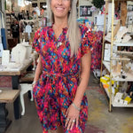 colorful romper on blonde model in store.