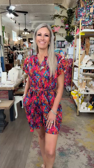 colorful romper on blonde model in store.