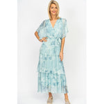 Woman wearing a light blue tie-dye dress on a white background