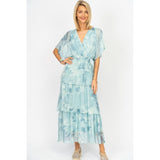 Woman wearing a light blue tie-dye dress on a white background