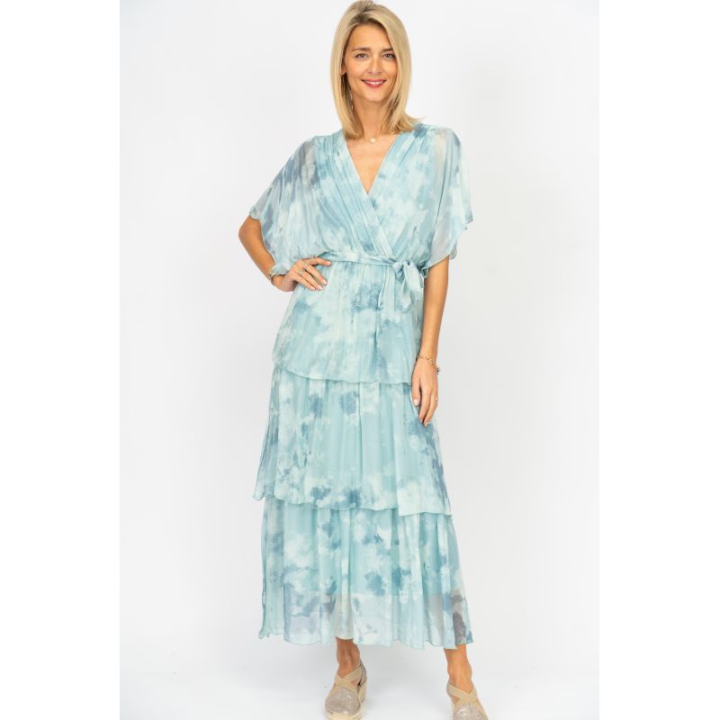 Woman wearing a light blue tie-dye dress on a white background