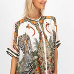 Woman wearing a patterned shirt with animal designs on a white background
