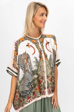 Woman wearing a patterned shirt with animal designs on a white background