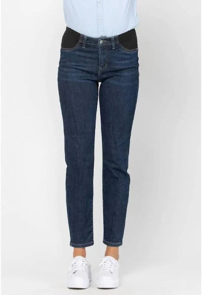 Person wearing dark blue jeans and a light blue shirt on a white background