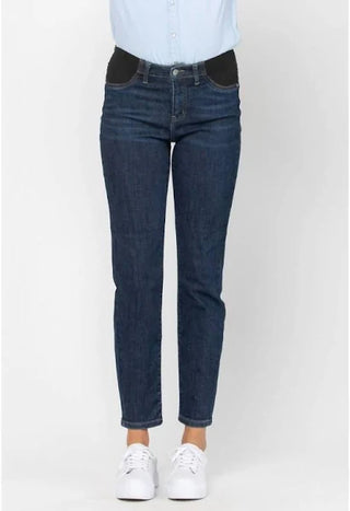 Person wearing dark blue jeans and a light blue shirt on a white background