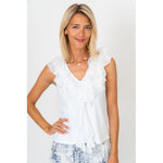 Woman wearing a white ruffled blouse against a plain background