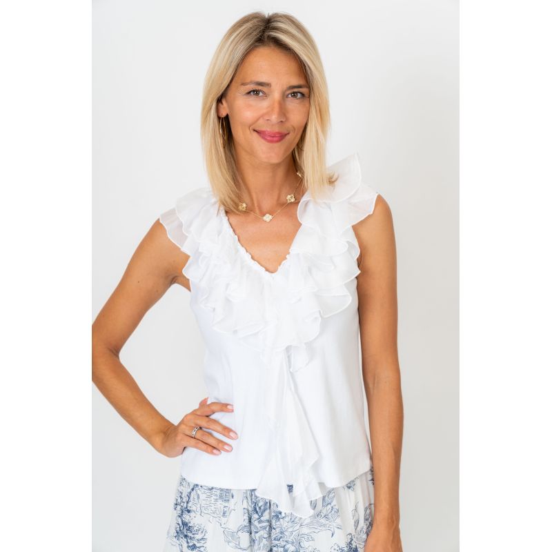 Woman wearing a white ruffled blouse against a plain background