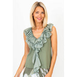 Woman wearing a green ruffled top on a white background