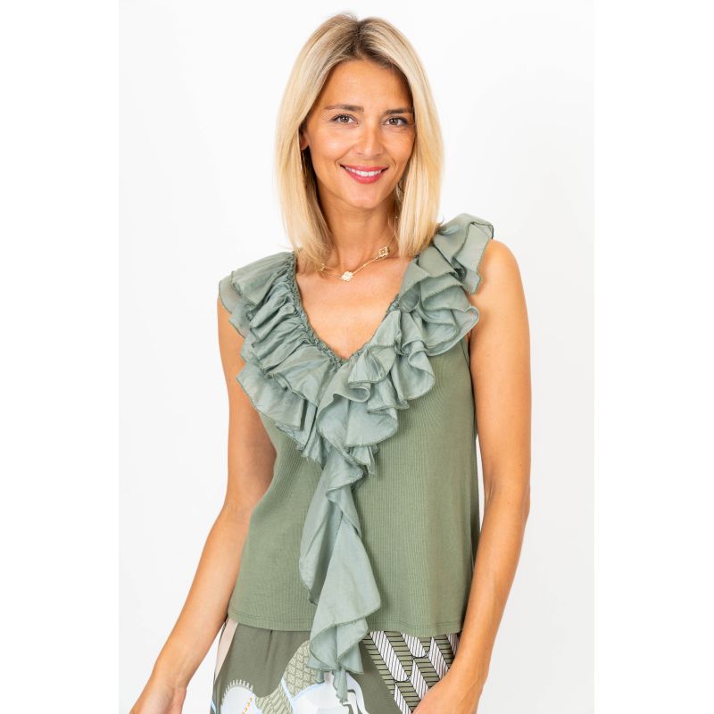 Woman wearing a green ruffled top on a white background