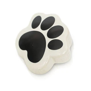 White dish shaped like a black paw print on a white background