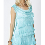 Woman wearing a light blue, tiered dress against a white background