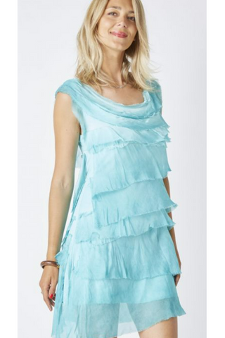Woman wearing a light blue, tiered dress against a white background