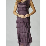 A woman wearing a purple silk ruffle dress with a V-neck neckline and sleeveless top. The dress features a tiered design with a longer hem in front.